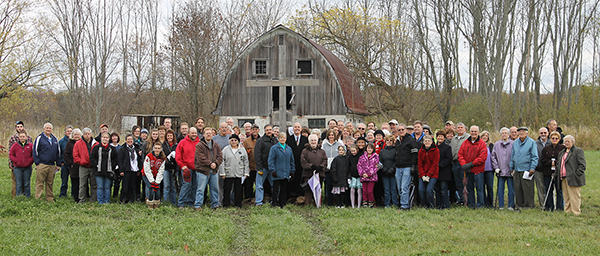 Middlefield UMC members stand in front of wood cross in field
