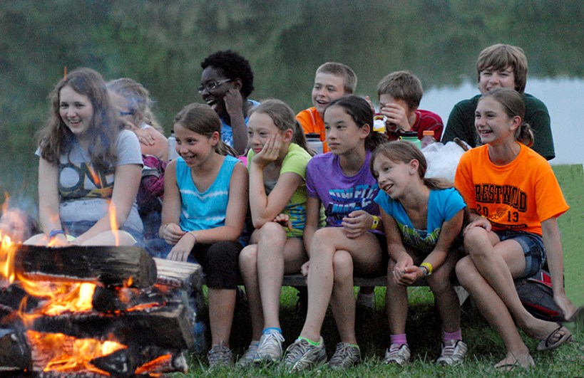 Kids sitting by the campfire