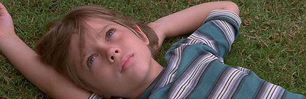 Boy laying in grass looking up