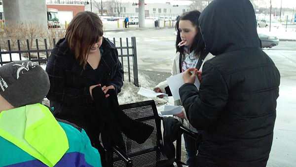 YOuth attaching scarves to bench
