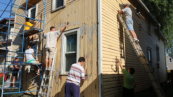 Nehemiah Mission Team painting and scraping house