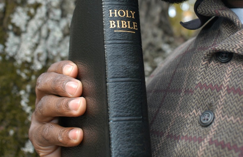 man's hand with Bible