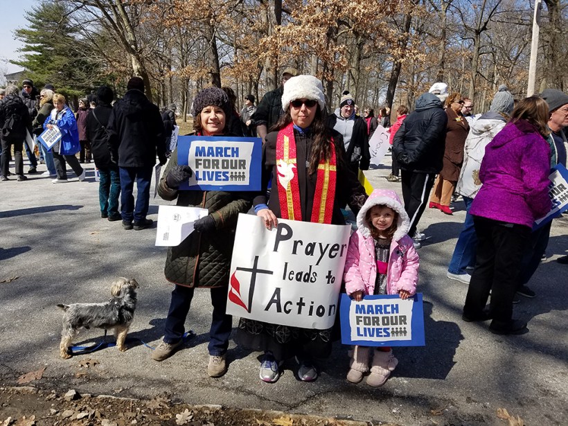 Rev. Abby Auman with her daughter and friend with sign "Prayer leads to action" at the Youngstown rally.