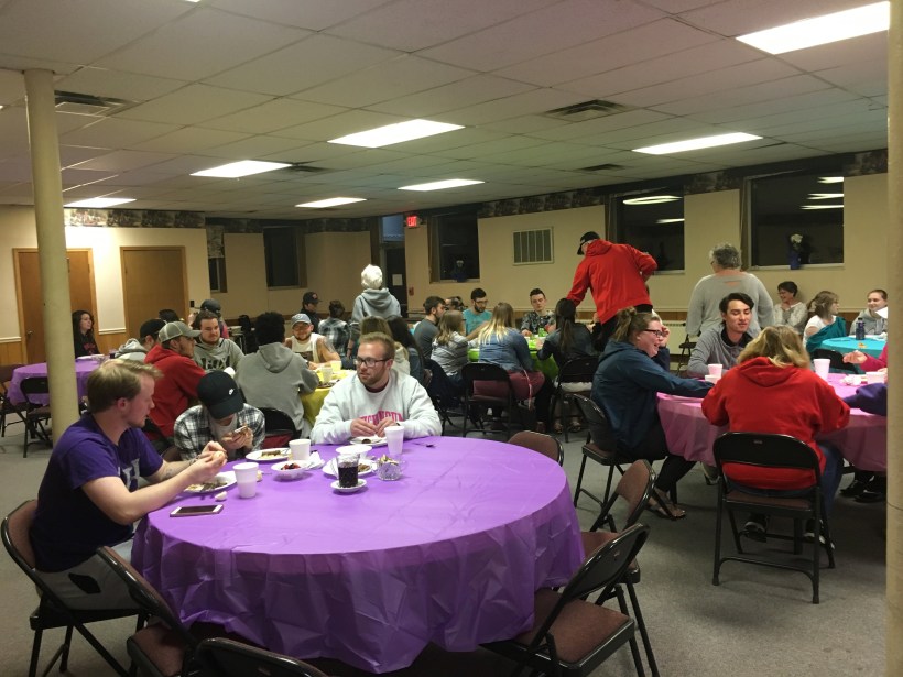 College Students studying at round tables, eating breakfast