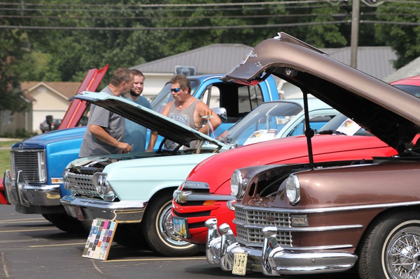 Guys discussing cars among the cars